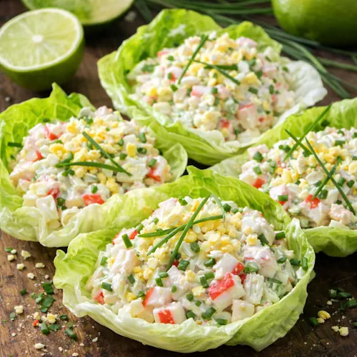 Krabsalade met limoenmayonaise op een rustieke houten tafel.
