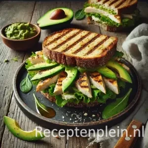 Zeer realistische foodfoto van een gegrilde kip sandwich met avocado en gemengde sla op een donker stenen bord op een rustieke houten tafel. Het geroosterde brood heeft duidelijke grillstrepen en is gevuld met plakjes gegrilde kipfilet met lichte blakering, romige avocado en een mix van groene slabladeren die natuurlijk uit het brood steken. De sandwich is doorgesneden en nonchalant gepresenteerd met enkele broodkruimels en kleine stukjes avocado op het bord en de tafel. Op de achtergrond staan een schaaltje met extra avocado, een mes en een gekreukelde linnen doek in zacht daglicht.