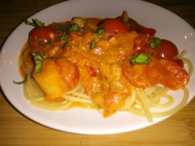 Zeevruchten met pasta in een gekruide paprika-tomatensaus