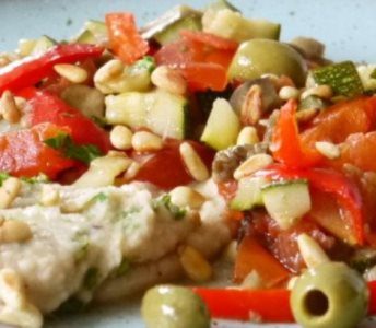 Zomers groentepakketje met groene olijven en pijnboompitten, geserveerd met boterbonenpuree