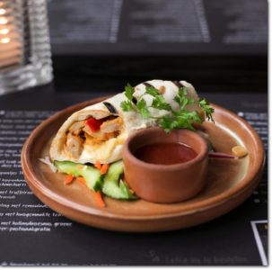 Wrap pollo van 't Zusje op een rustieke houten tafel.